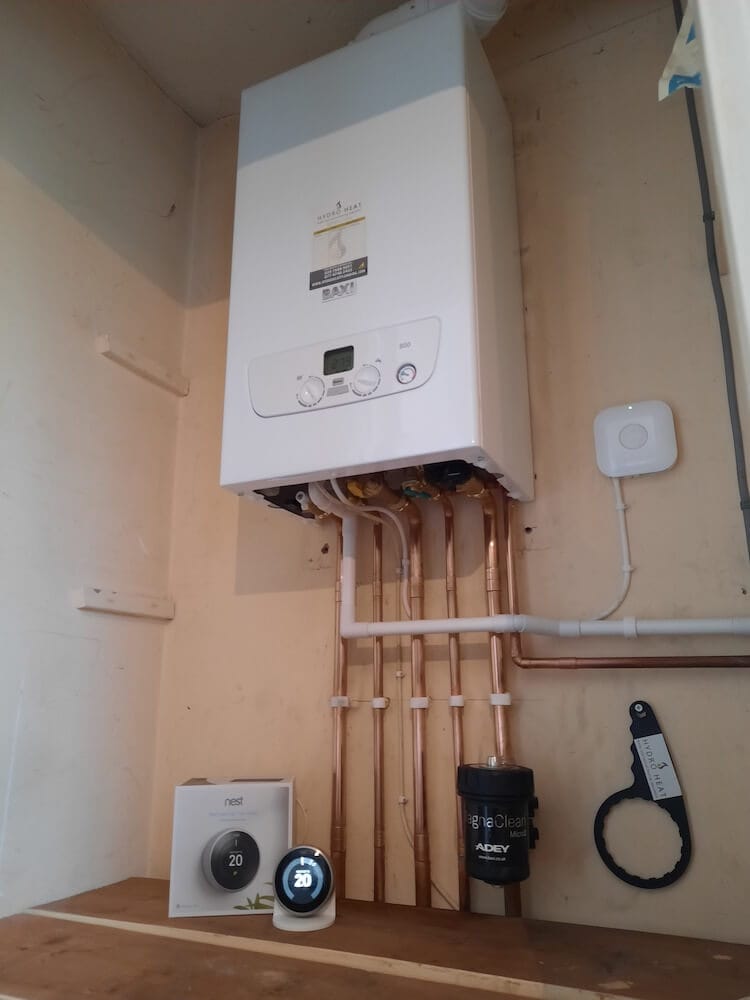 Wall-mounted Baxi boiler with copper pipework, a magnetic filter and a heating thermostat